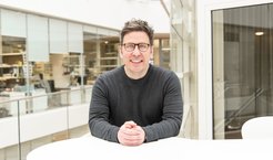 Peter Tessarz sitzt an einem Tisch.